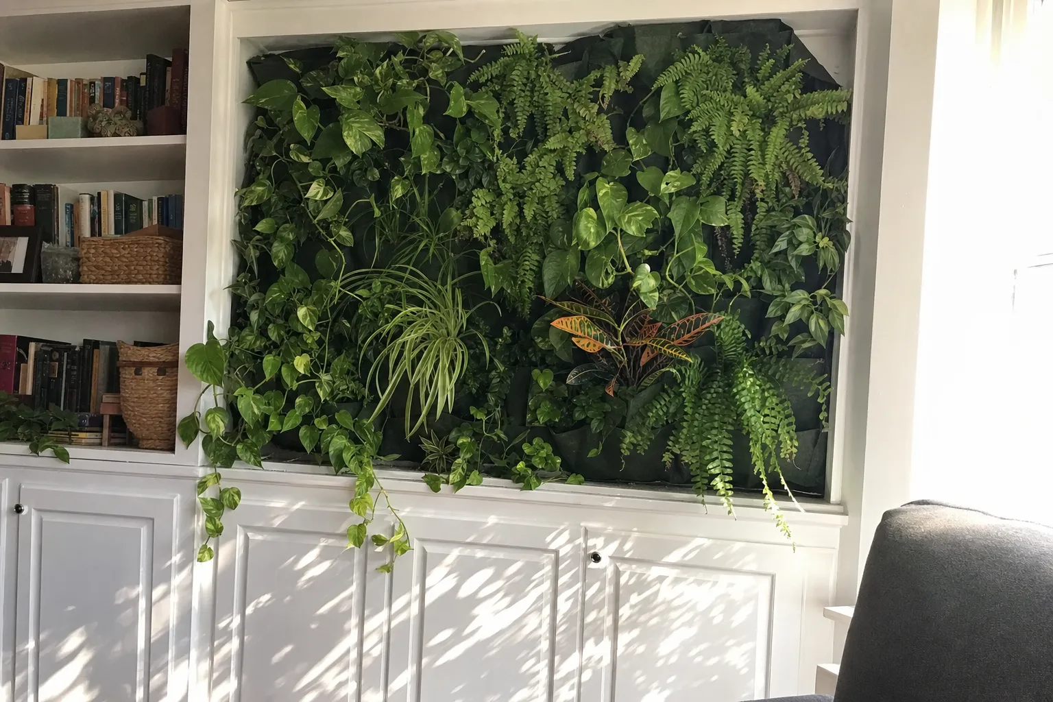 Frodig grön växtvägg med ormbunkar och hängande växter på en vägg inomhus